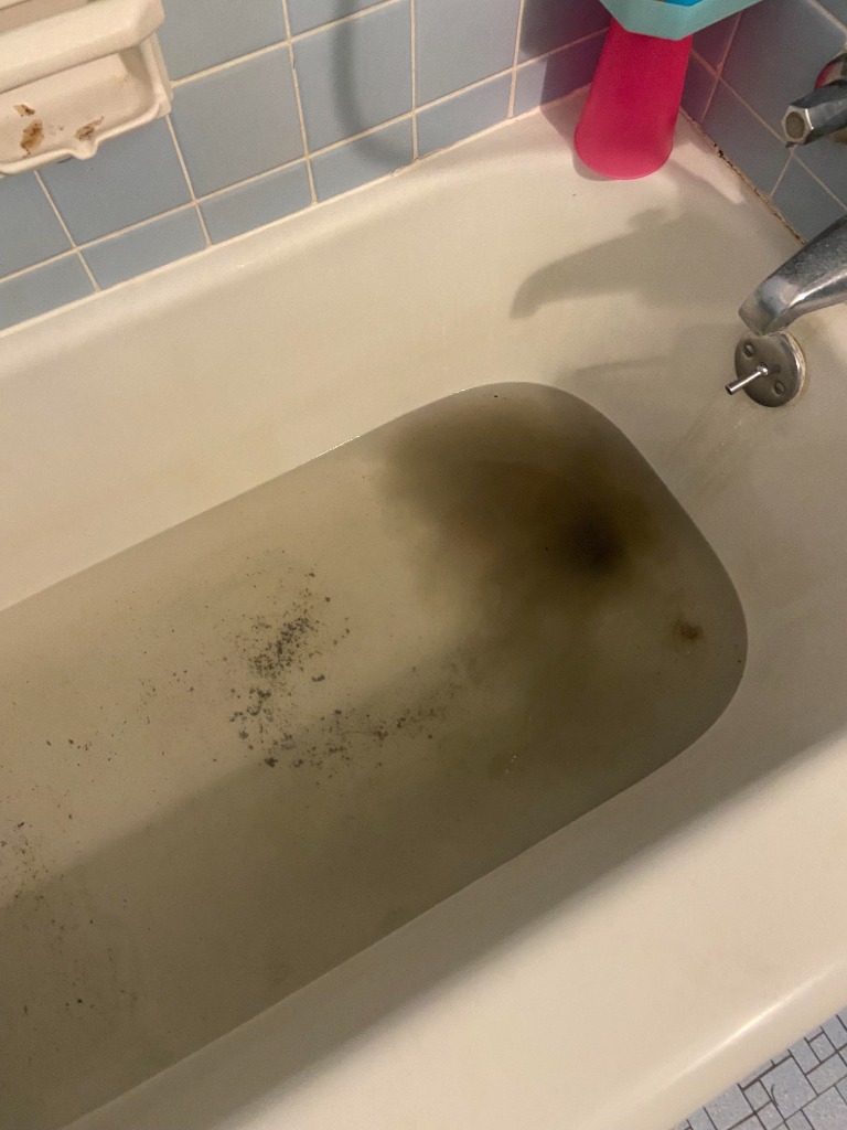 Bathtub Drain Sewage Backup and Sediment Bathtub drain backing up with dirty contaminated wastewater and sewage sediment in residential home