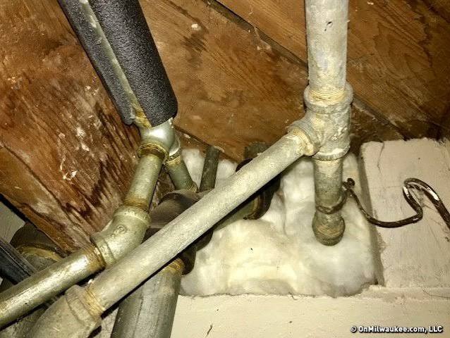 Exposed Attic Water Supply Pipes with Insulation Exposed residential water supply pipes in an attic with insulation vulnerable to freezing during cold snaps in Miami