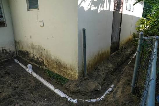Exterior Main Sewer Line and Cleanout Trench Exterior underground sewer cleanout drainage line and pipe trench along residential foundation in Miami-Dade