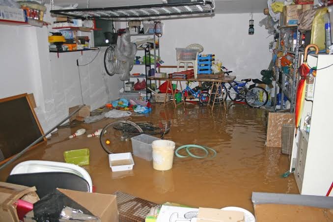 Flooded Basement and Stored Belongings Submerged in Water Standing floodwater submerging stored boxes, household belongings, and furniture in residential basement in Miami